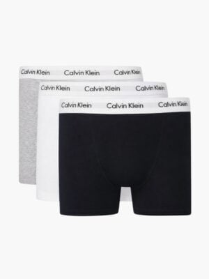 שלישיית תחתוני בוקסר שחורים של קלווין קליין פרוסים זה מעל זה, המציגים את חגורת המותן הלבנה עם הלוגו השחור.