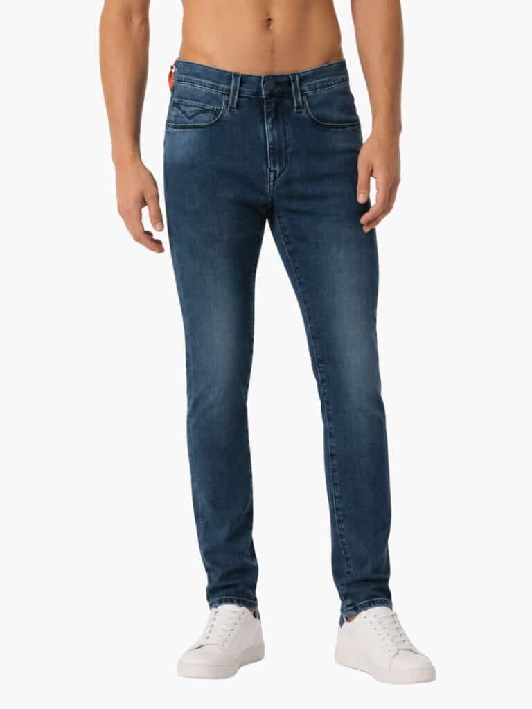 ג'ינס ליוויס לגבר בגוון כחול משופשף (Washed), גזרה ישרה/צרה עם תווית אדומה ופאץ' לוגו אחורי מעור שחור למראה פרימיום מודרני.
