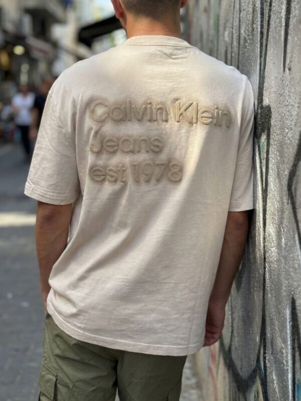 קלווין קליין טי שירט בגוון שמנת עם הדפס בולט בגב