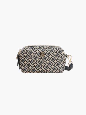 תיק צד מלבני של טומי הילפיגר בבד ארוג בצבע בז' עם דוגמת מונוגרם כחול כהה, רצועת כתף מעור כהה וסגירת רוכסן זהובה.