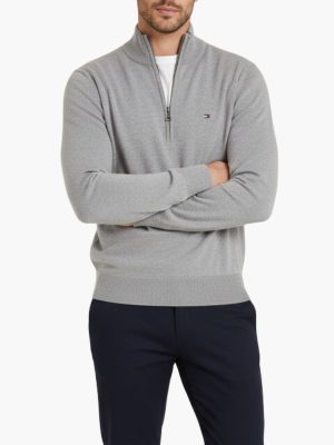 סריג אפור של טומי הילפיגר עם צווארון גבוה ורוכסן קצר בחזית ולוגו קטן רקום בצד שמאל של החזה