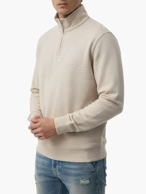 קפוצ'ון באלר בגוון בז' בהיר עם רוכסן רבע, צווארון גבוה ולוגו רקום עדין על החזה