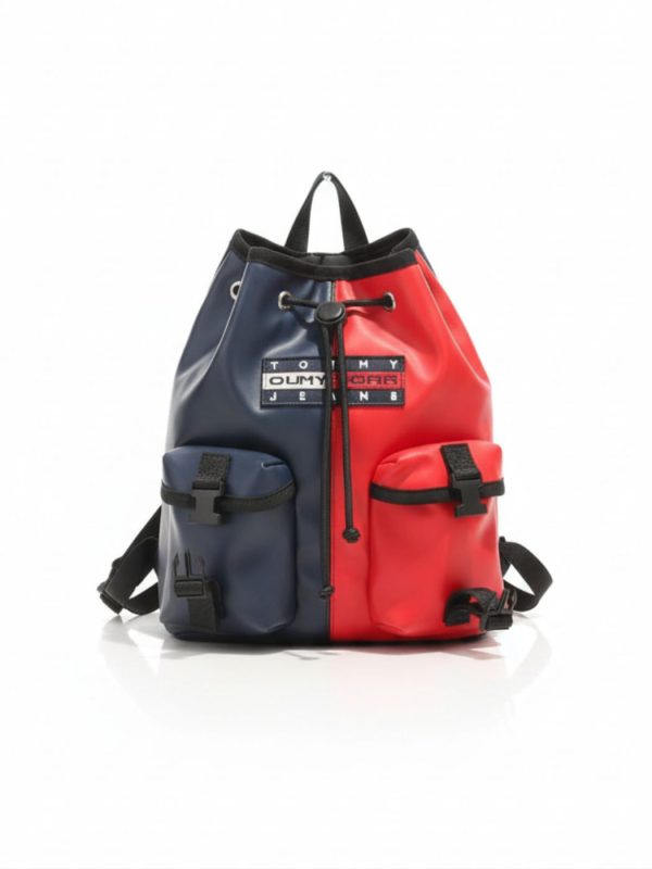 תיק גב דו-צבעי כחול ואדום של טומי הילפיגר עם סגירת שרוך, שתי כיסים קדמיים ורצועות מתכווננות בגב.