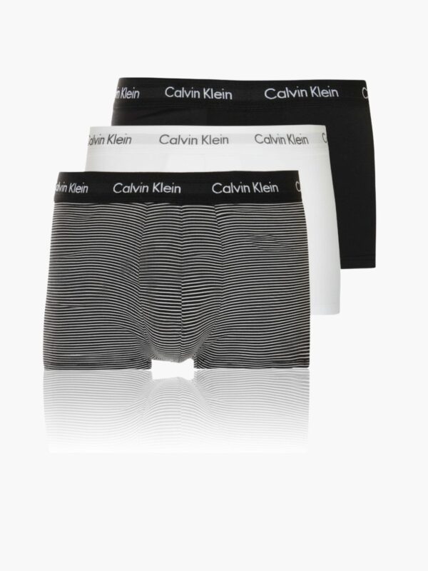 שלושה זוגות תחתוני בוקסר של קלוין קליין בצבעים שחור, לבן ופסים דקים בשחור-לבן עם גומי מותן ממותג.