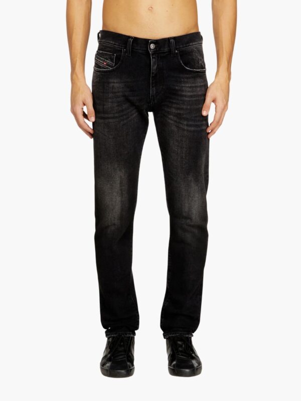 ג׳ינס שחור דהוי של דיזל בגזרה צרה, עם חמישה כיסים, סגירת כפתור ורוכסן, ותווית עור מאחור