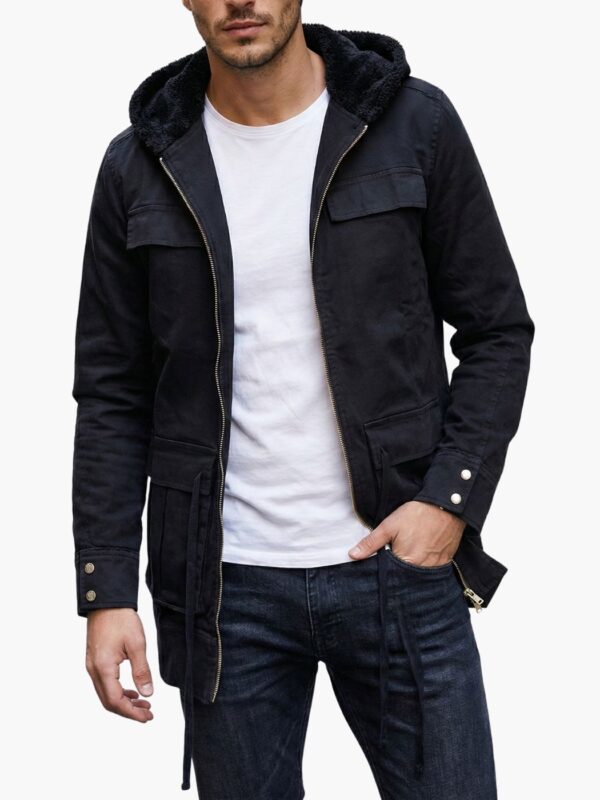 מעיל שחור של טי-בון עם רוכסן קדמי מלא, שני כיסים גדולים עם סגירה, שרוך במותן וכובע עם פרווה שחורה פנימית