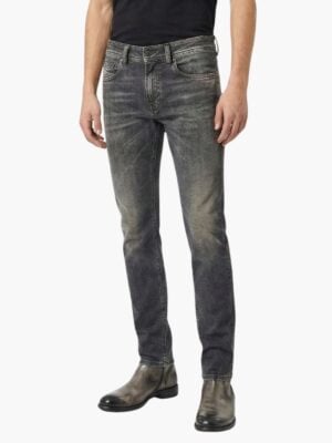 ג’ינס אפור של דיזל בגזרה צרה עם שטיפה כהה-בהירה, דיטיילים עדינים, כיס קדמי עם תג אדום ותפירה מודגשת.