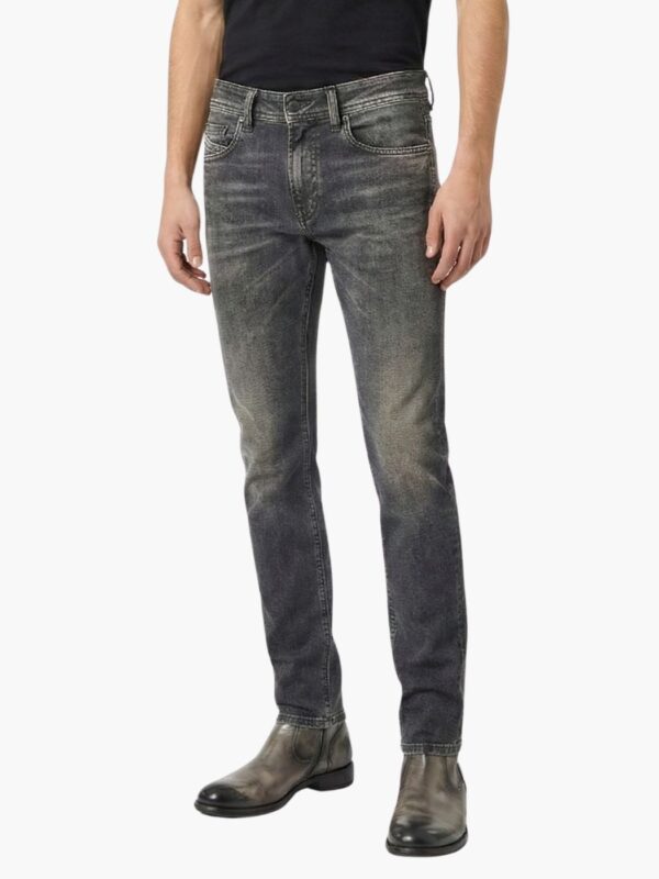 ג’ינס אפור של דיזל בגזרה צרה עם שטיפה כהה-בהירה, דיטיילים עדינים, כיס קדמי עם תג אדום ותפירה מודגשת.