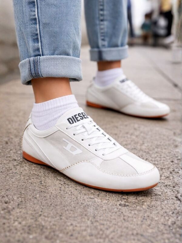 נעלי סניקרס לבנות של דיזל עם שילוב עור וזמש בהיר, שרוכים לבנים, לוגו דיזל בצד וסוליה חומה שטוחה.