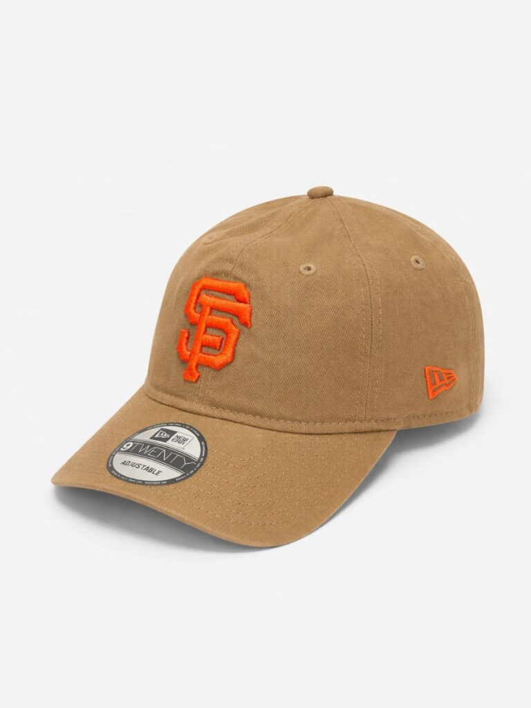 כובע מצחייה ניו ארה (New Era) דגם 9TWENTY בצבע חום קאמל (Camel) עם לוגו SF כתום רקום של סן פרנסיסקו ג'איינטס ורצועה אחורית.
