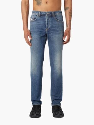 ג'ינס כחול של דיזל בגזרה רגילה, שטיפה קלאסית עם הבהרות קלות, חמישה כיסים, סגירת כפתור ורוכסן.