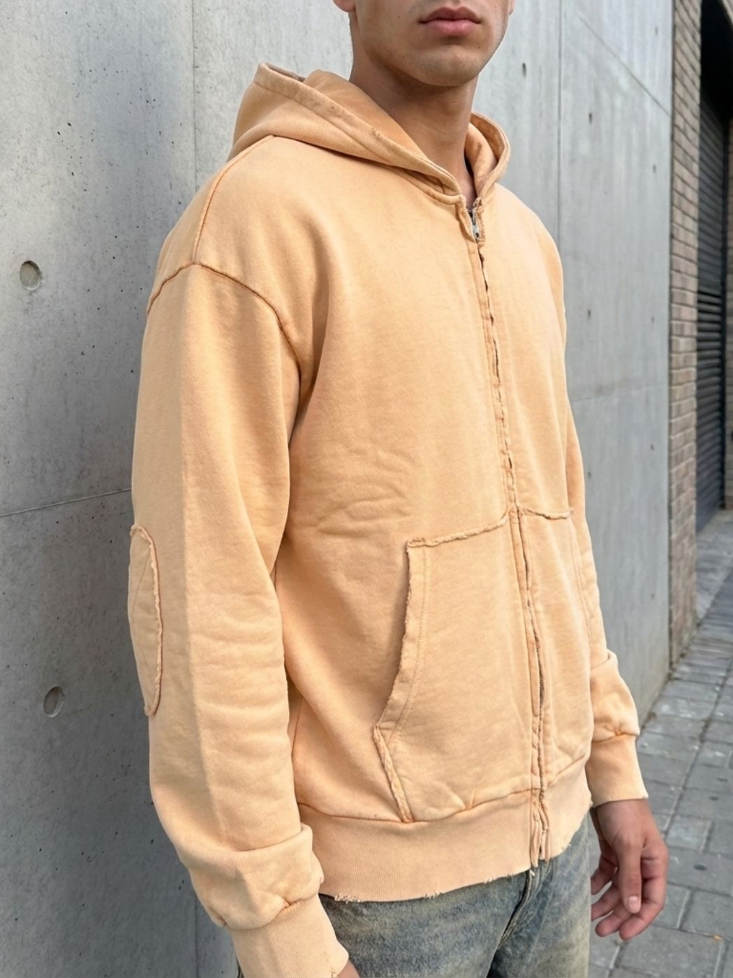 קפוצ׳ון בצבע חול של טי-בון עם קפוצ׳ון רוכסן קדמי מלא כיסים קדמיים תפורים וגימורי בד חשופים