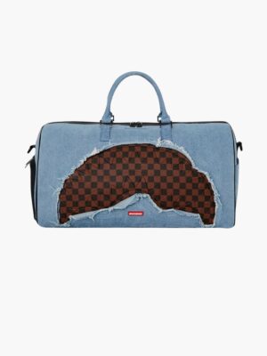 תיק דופל גדול של ספרייגראונד בג’ינס כחול עם קרעים סביב הדפס שחמט חום־שחור בצורת כריש, בטנה אדומה וידיות ג’ינס.