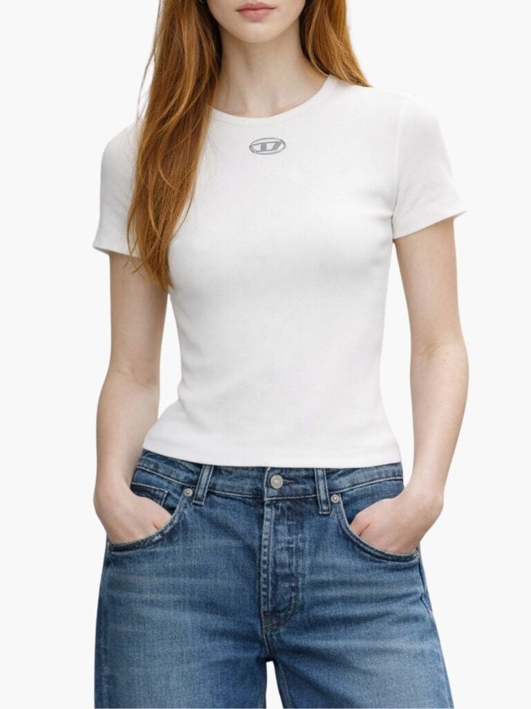 דוגמנית לובשת טי שירט לבנה צמודה מבד ריב עדין עם לוגו Oval D מתכתי של המותג Diesel באתר STOR75.