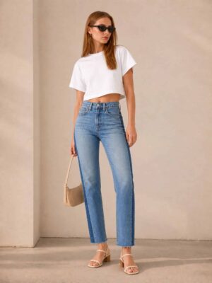 לוק אורבני קיצי שמשלב ג'ינס וינטג' בהיר של Levi's עם חולצת קרופ קצרה וסנדלי עקב.