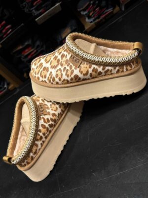 כפכפי פלטפורמה של מותג UGG בהדפס מנומר עם סוליה עבה, עיטור רקום בשוליים ובטנת צמר רכה.