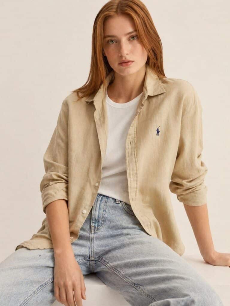 חולצת פשתן איכותית לנשים מבית Polo Ralph Lauren בגוון בז' טבעי, עם לוגו הפרש הרקום בכחול ושרוולים ארוכים - למראה קלאסי ונינוח.