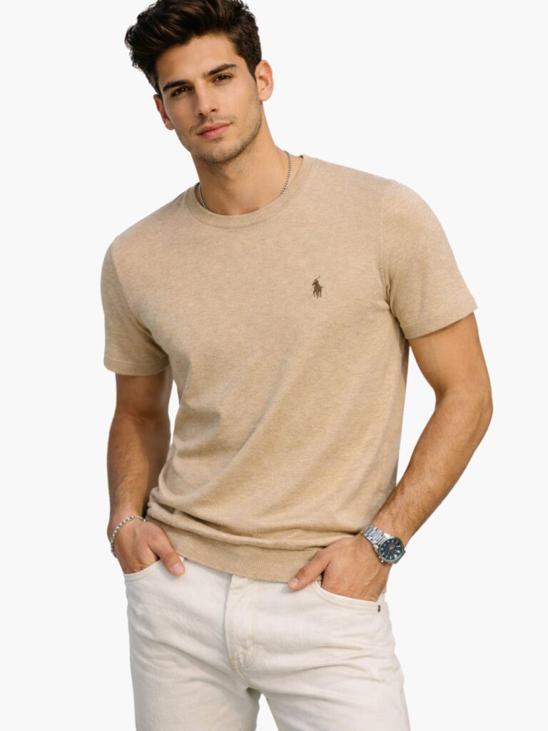 דוגמן לובש חולצת סריג דק קצרה של המותג Polo Ralph Lauren בצבע בז' קאמל, עם לוגו הפרש האיקוני רקום בחזית וסיומות ריב בשרוולים.