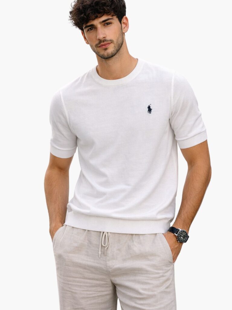 חולצת סריג קצרה בצבע לבן חגיגי של המותג Polo Ralph Lauren, הכוללת לוגו פרש רקום בכחול כהה וסיומות ריב בשרוולים למראה אלגנטי.