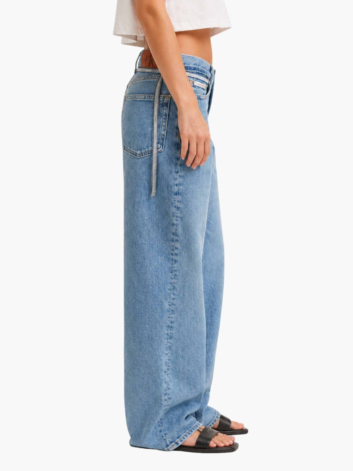 ג'ינס קלווין קליין לנשים בגזרת באגי רחבה (Baggy) ומותן נמוך, בצבע כחול עם חגורת בד ממותגת דקה