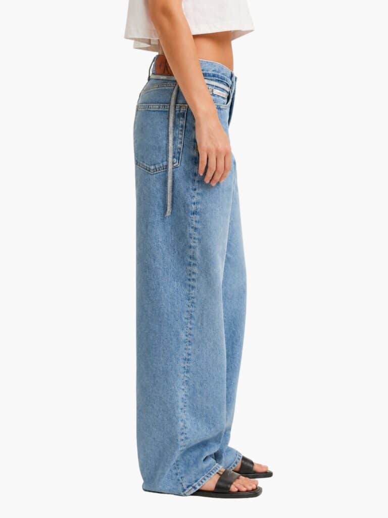 ג'ינס קלווין קליין לנשים בגזרת באגי רחבה (Baggy) ומותן נמוך, בצבע כחול עם חגורת בד ממותגת דקה