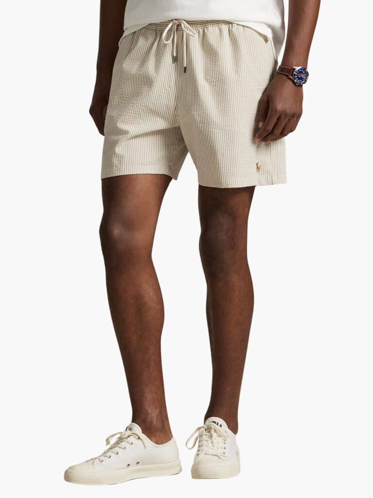 בגד ים יוקרתי לגבר מבית Polo Ralph Lauren בעיצוב פסים בצבעי בז' ולבן, עשוי בד סירסאקר (מכווץ) איכותי עם לוגו הפרש הצבעוני רקום ברגל.