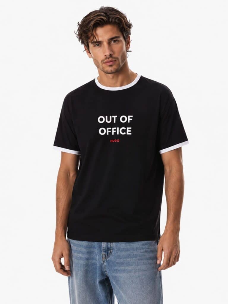 טי שירט הוגו Out Of Office שחורה לגבר עם גימורים לבנים בצוואר ובשרוולים וכיתוב בולט בחזית.