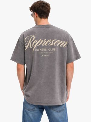 חולצת טי שירט אוברסייז לגבר של המותג Represent בצבע אפור פחם שטוף, עם לוגו Owners Club בכיתוב מסולסל בחזית ובהדפס ענק בגב.