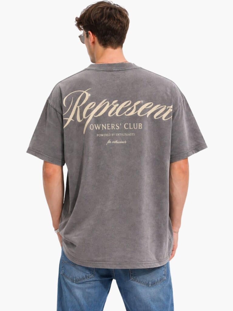 חולצת טי שירט אוברסייז לגבר של המותג Represent בצבע אפור פחם שטוף, עם לוגו Owners Club בכיתוב מסולסל בחזית ובהדפס ענק בגב.