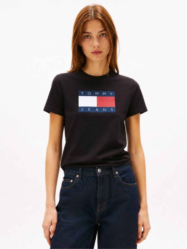 חולצת טי שירט שחורה לנשים מבית טומי ג'ינס Tommy Jeans, גזרה רגילה (Regular) עם הדפס לוגו דגל צבעוני גדול במרכז החזה למראה קונטרסטי.