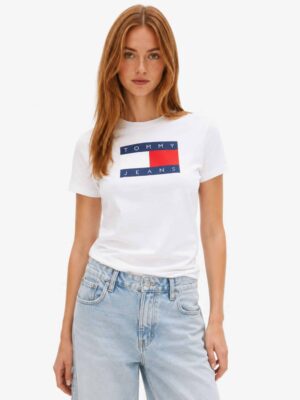 חולצת טי שירט לבנה לנשים מבית טומי ג'ינס Tommy Jeans, גזרה רגילה (Regular) עם הדפס לוגו דגל המותג בגדול במרכז החזה למראה בולט.