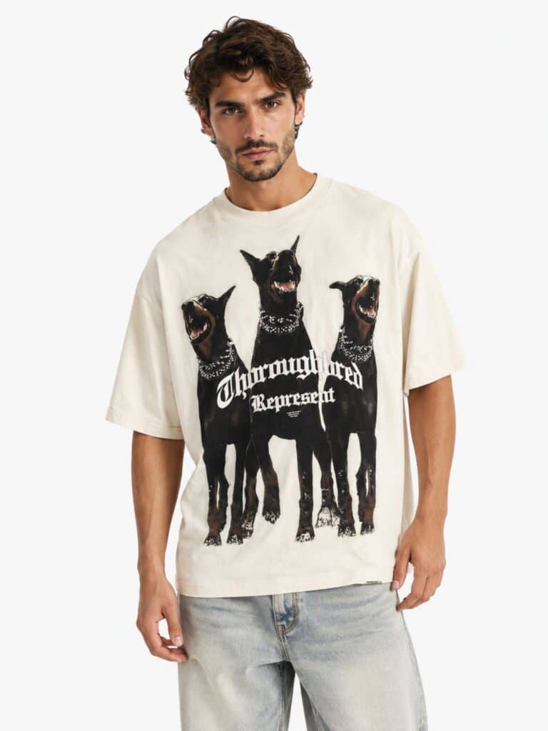 חולצת טישירט רפרזנט בצבע שמנת וינטג' דגם Thoroughbred, גזרת אוברסייז עם הדפס גדול של שלושה כלבי דוברמן וכיתוב גותי.