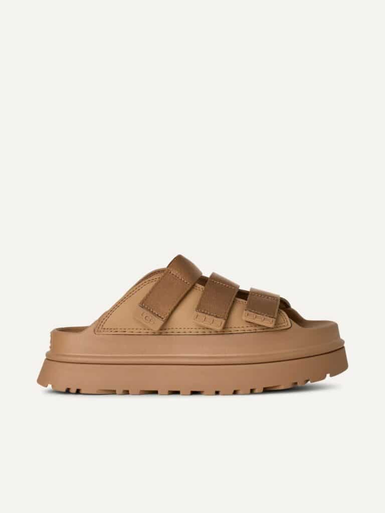 כפכפי פלטפורמה UGG לנשים דגם GoldenGlow Slide בגוון חום עם שלוש רצועות מתכווננות וסוליה קלה.