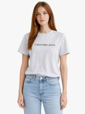 כיתוב Calvin Klein Jeans שחור מודפס על חולצה אפורה.