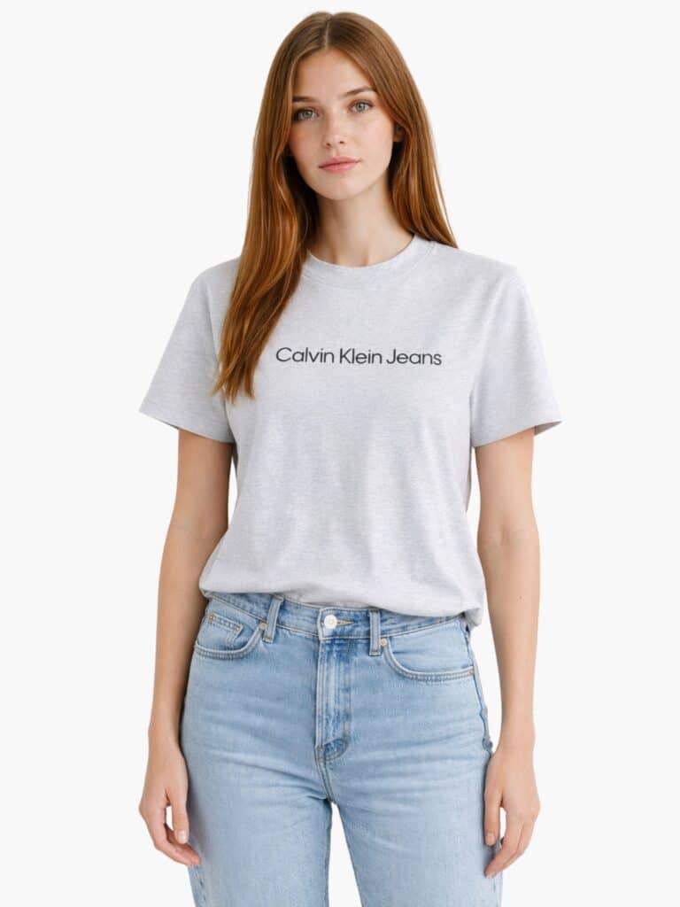 כיתוב Calvin Klein Jeans שחור מודפס על חולצה אפורה.