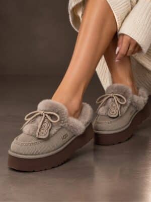- כפכפי UGG אפורים עם פלטפורמה חומה על רגלי דוגמנית